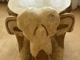a small table with an elephant on it in front of a window
