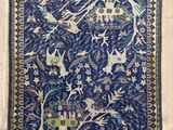 un tapis bleu orné d'oiseaux et de fleurs posé sur un parquet