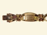 a close up of a gold bracelet with a picture on it