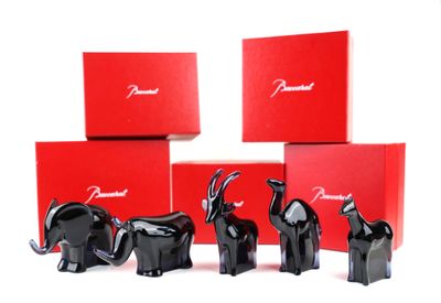 four black elephant figurines in front of red boxes on a white surface