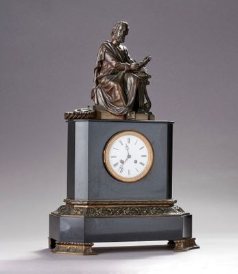 une statue d'un homme assis au sommet d'une horloge