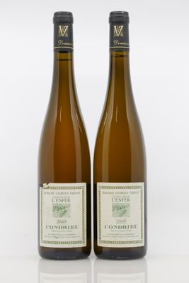 deux bouteilles de vin posées l'une à côté de l'autre sur une surface blanche