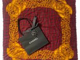 a chanel bag and a chanel scarf on the table