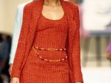 a woman that is walking down the runway with a hat on her head