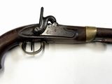 un vieux fusil exposé sur une surface blanche