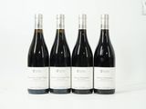 quatre bouteilles de vin sont alignées sur une surface blanche