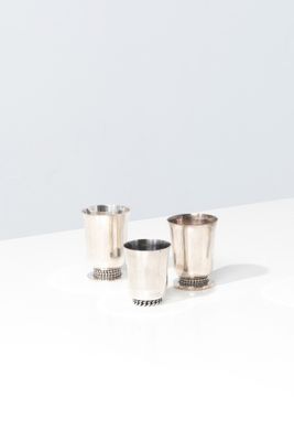 two silver cups sitting on top of a table next to each other
