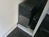 a computer on a desk in a corner of a room