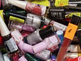 a pile of nail polish and nail vares in a bin