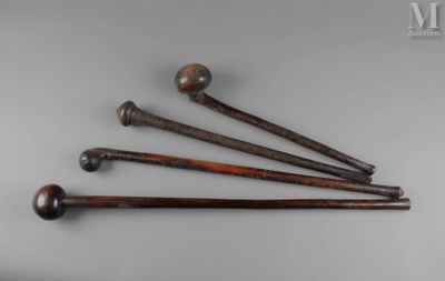 four wooden baseball bats sitting on top of a white surface