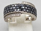 a close up of a ring with black and white diamonds