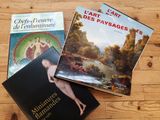 trois livres posés sur une table en bois