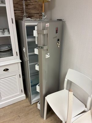 un réfrigérateur et une chaise dans un coin de la pièce