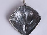 a silver pendant with a picture of a woman on it