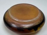 a brown and black bowl sitting on a white table