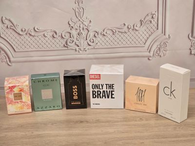 cinq boîtes de parfum posées les unes à côté des autres sur une table