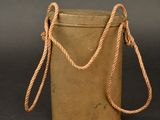 an old metal bucket with a rope around it on a black background