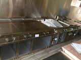 une cuisine avec de nombreux plans de travail en inox