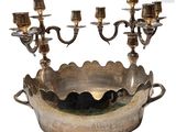 a large silver bowl with five candelabs on it