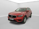 un SUV Volvo rouge garé dans une pièce blanche