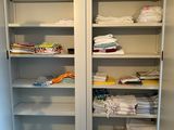 a tall cabinet with lots of folded towels in it