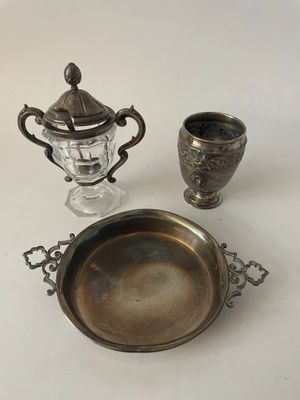un plateau en argent sur lequel sont posés une tasse et un vase en argent, sur une table blanche