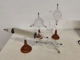 trois lampes en verre posées sur une table, avec un stylo et un crayon