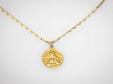 un collier plaqué or avec une pièce suspendue à une chaîne en or