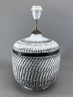 un vase noir et blanc surmonté d'une lampe