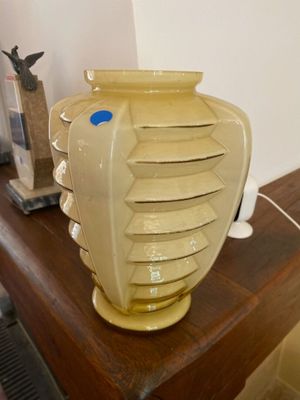 a yellow vase sitting on top of a wooden table