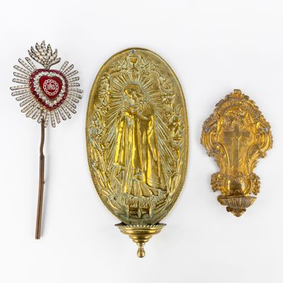 three pieces of gold and red brooches on a white surface
