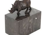 statue d'un rhinocéros posée sur un bloc de marbre