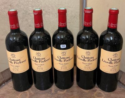 six bouteilles de vin rouge sont alignées sur un tonneau en bois