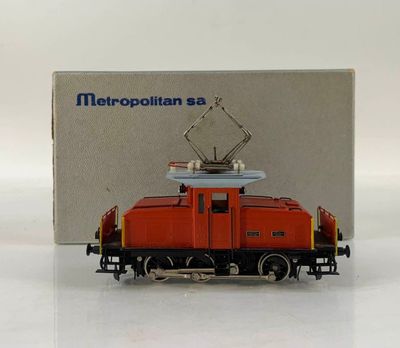 a toy train on a white surface with a box in the background