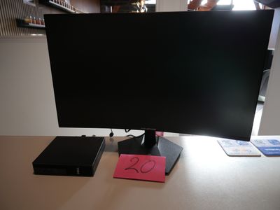 a computer monitor sitting on top of a desk next to a book