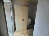 un placard dans un coin d'une pièce, dont la porte est ouverte