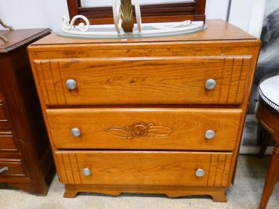 une commode en bois à trois tiroirs, surmontée d'un miroir