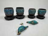 six pieces of blue and green pottery sitting on top of a white table