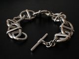 a silver bracelet with a cross on it on a black surface