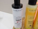 three bottles of lotion sitting on a cutting board