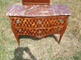 une commode au plateau en marbre au milieu d'un champ