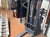 un chariot élévateur dans un entrepôt où se trouvent de nombreuses palettes