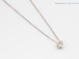 a close up of a necklace with a diamond on a chain