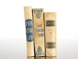 three books sitting on top of each other on a table