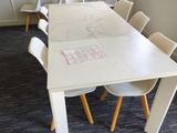 tables and chairs in a meeting room with a flat screen tv on the wall