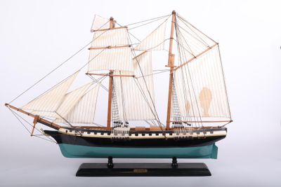 a model of a sailboat on a wooden stand