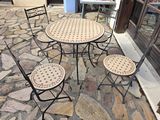 four chairs and a table on a stone patio