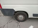 a white van with a flat tire parked in a parking lot