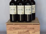 six bouteilles de vin se trouvent dans une caisse en bois posée sur une table