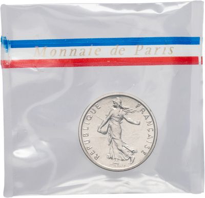 une pièce de monnaie dans un sachet en plastique orné d'un ruban rouge, blanc et bleu